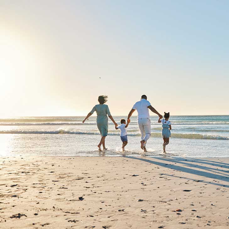 family walking on the beach after skipping loan payment