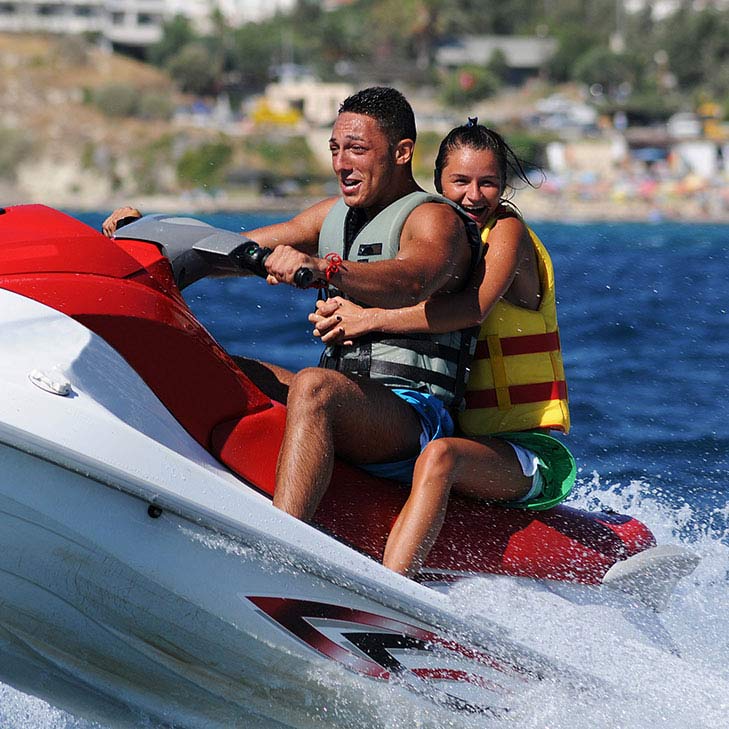 Father and daughter riding on a jet ski