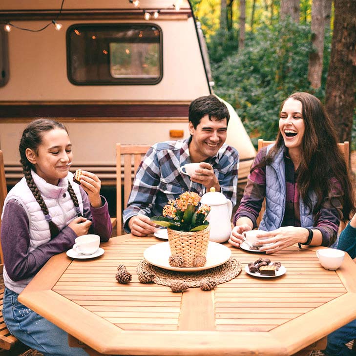 Family drinking tea in front of rv