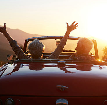 Couple driving car obtained through Auto Loan car towards sunset